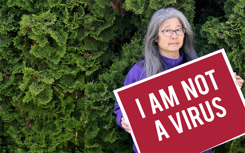 Megan Kitagawa holding sign reading "I am not a virus"