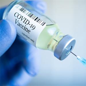 COVID-19 vaccine vial and hypodermic needle