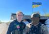 David Pavenko posing with soldier at roadside checkpoint in Ukraine.