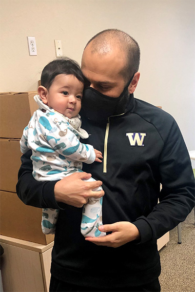 Ramon Borunda, seen here his son Elias, is UW Tacoma’s associate director of residence life. Behind them are boxes of Thanksgiving meals.