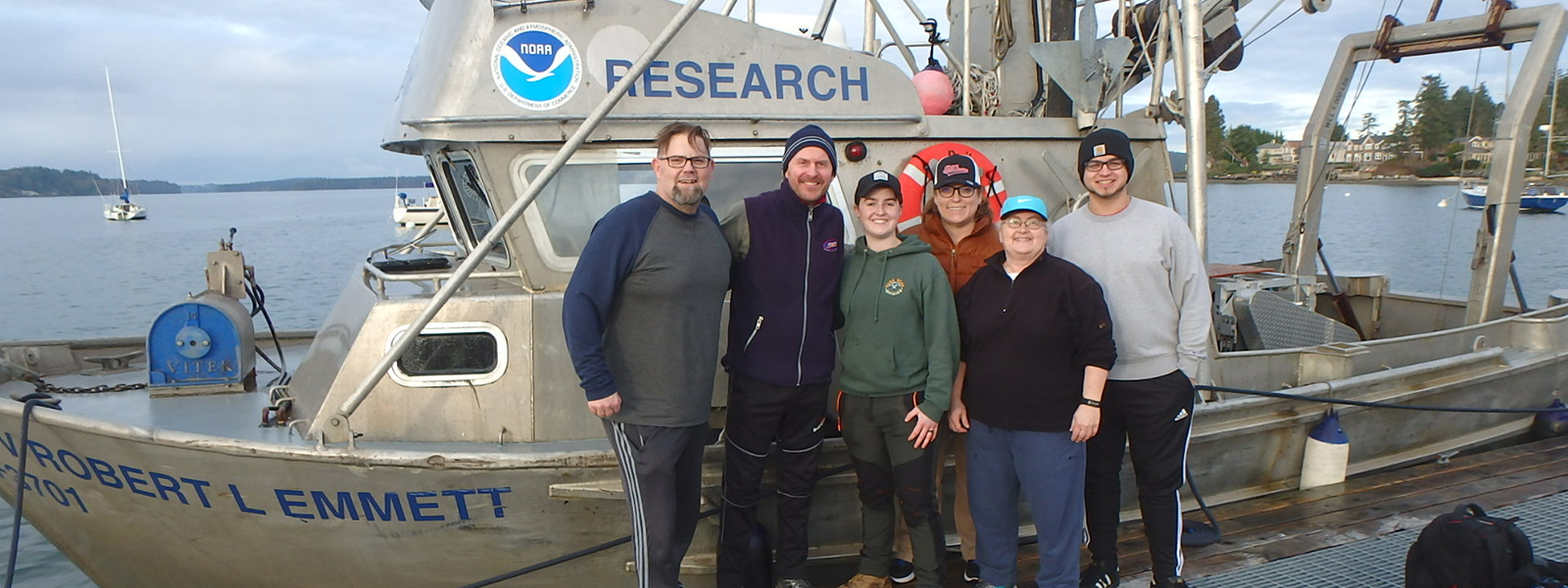 Portrait of research team in front of NOAA vessel Robert L. Emmett