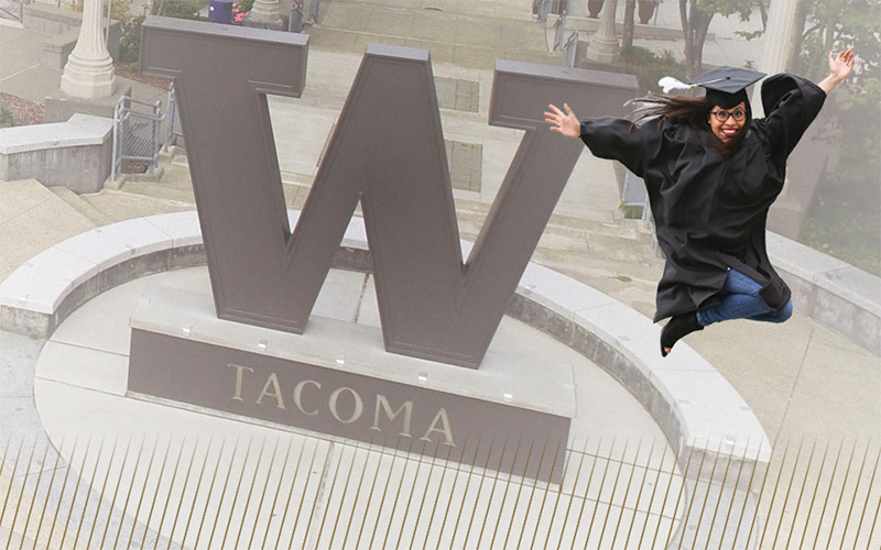UW Tacoma grad soaring through air in front of steel W.