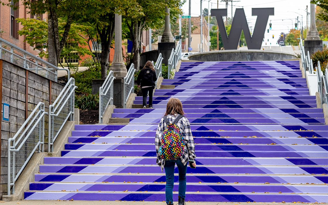 UW Tacoma Grand Staircase with supergraphics depicting a giant purple arrow pointing up the stairs to the steel W.
