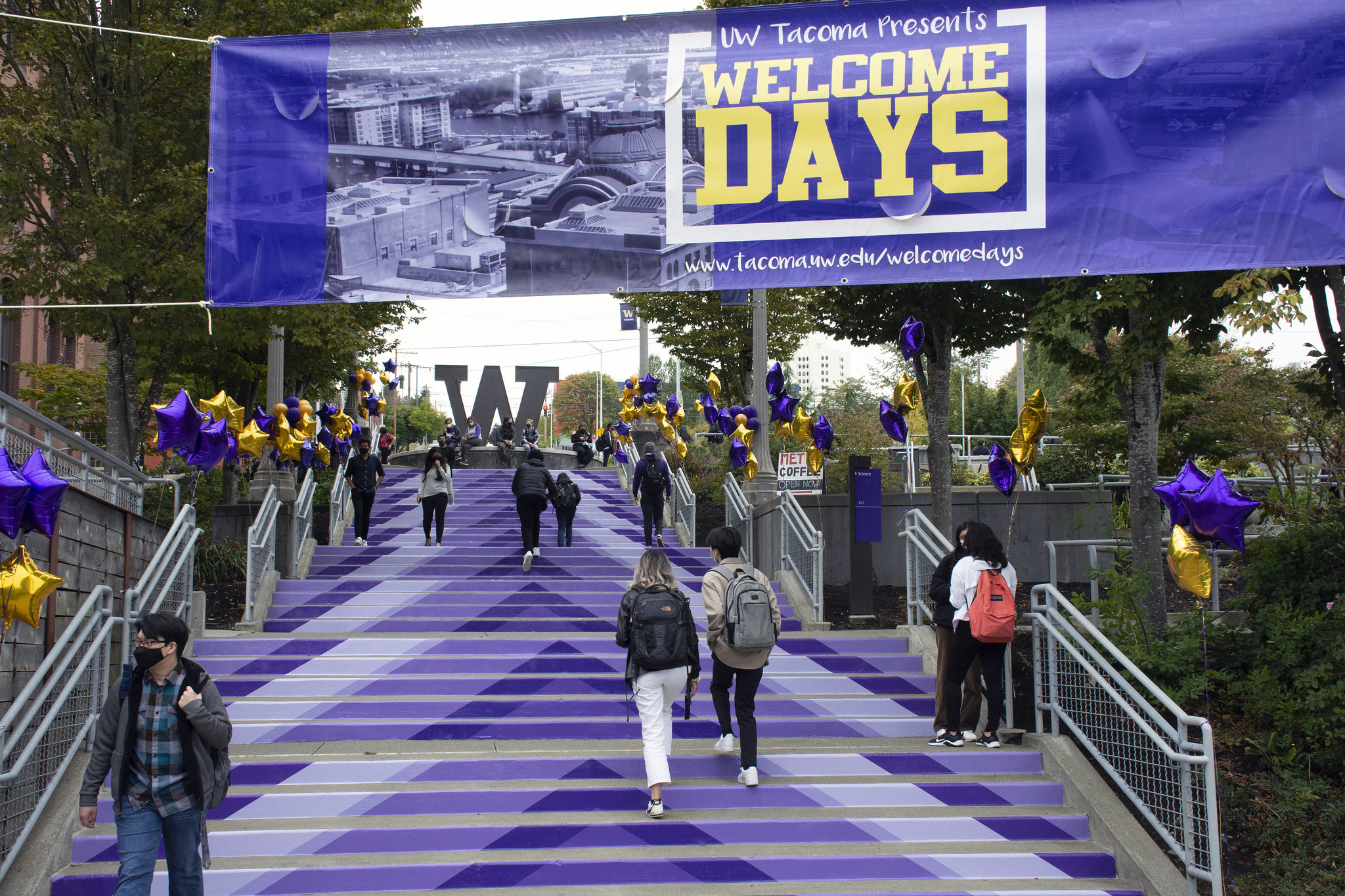 UW Tacoma's autumn quarter 2021 Convocation. Image features students walking up the campus grand staircase.