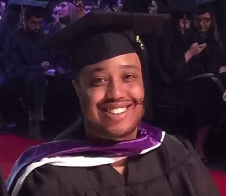 Omari Amili, '14, '16, in 2016 commencement ceremony wearing UW Tacoma Master's hood.