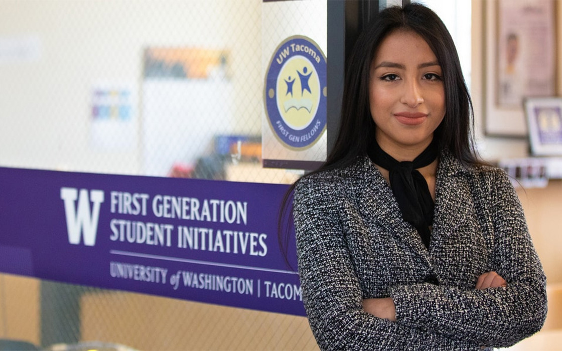 Maria Crisostomo, '19, posing in front of entrance to UW Tacoma First Generation Student Initiatives office