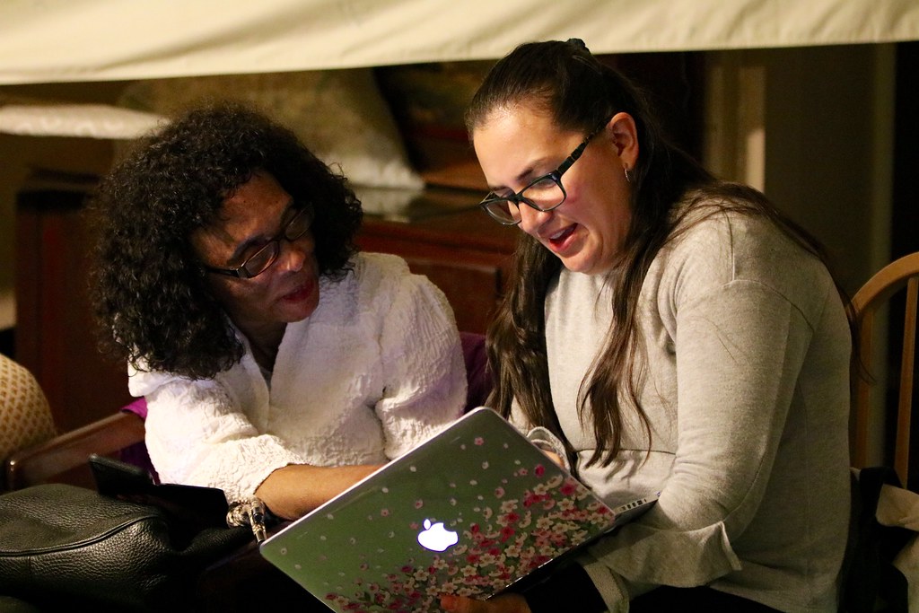 Dr. Marian Harris talking with UW Tacoma graduate student Zea Mendoza, who is holding a laptop computer.