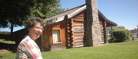 Mary Bowlby posed in front of Job Carr Cabin Museum