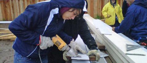 UW Tacoma student wielding a power tool at a Habitat for Humanity construction site.
