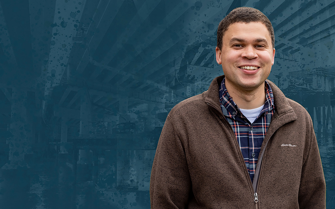 Graphic illustration featuring faculty member Lorne Arnold. The background features the underspan of a bridge. Arnold is in the foreground. He is smiling and is wearing a brown zip up jacket with a plaid button up underneath.