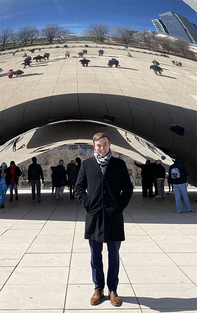 Spencer Tyson, '22, B.A. Healthcare Leadership, posed in front of Anish Kapoor's sculpture Cloud Gate ("The Bean") in Chicago, Ill.