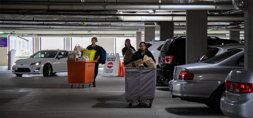 Court 17 parking garage with cars and students pushing carts
