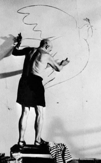 Artist Pablo Picasso in his studio drawing a dove of peace