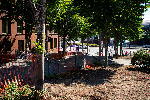 View of campus landscape along Grand Staircase, with orange construction fencing and newly exposed soil.