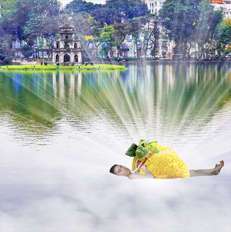 PICTURED: A photo composite depicting a man wrapped in a Vietnamese food item floating in a lake adjacent to a city street visible through trees in the distance. Light appears to emanate from the man.