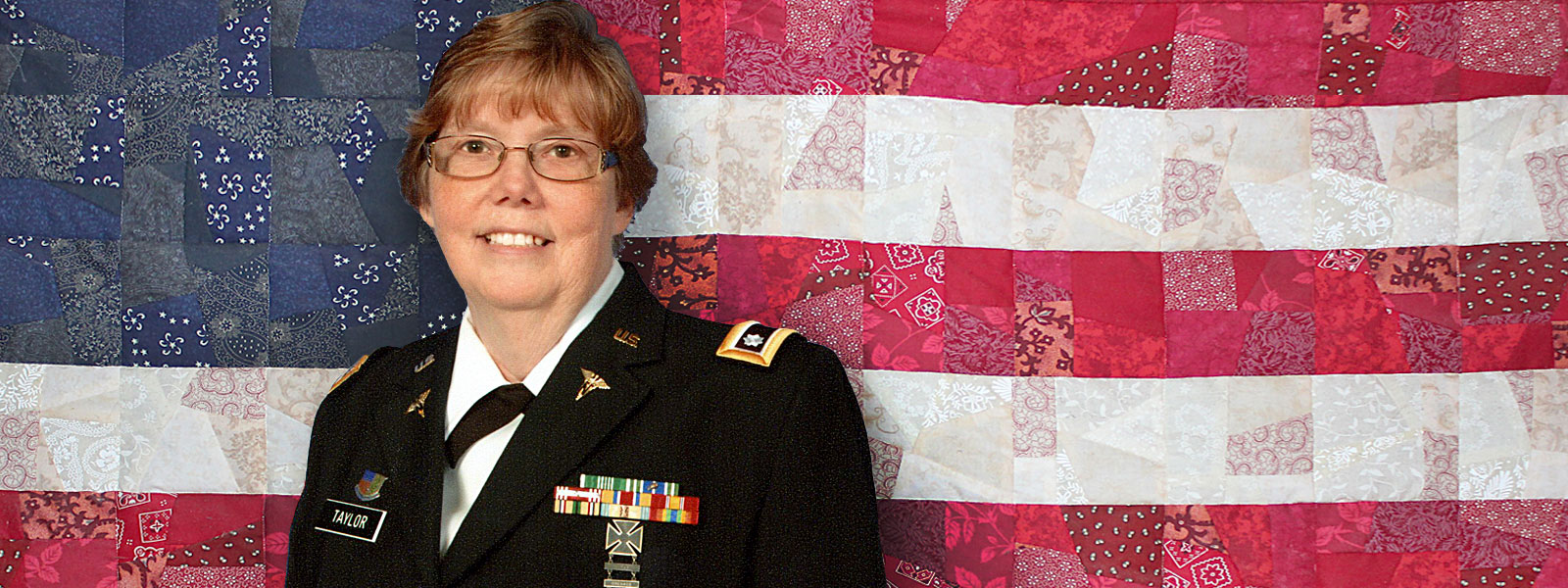 Patti Taylor, '93, UW 2018 Distinguished Alumni Veteran Award recipient, with patched-fabric mosaic reminiscent of the U.S. flag in background.