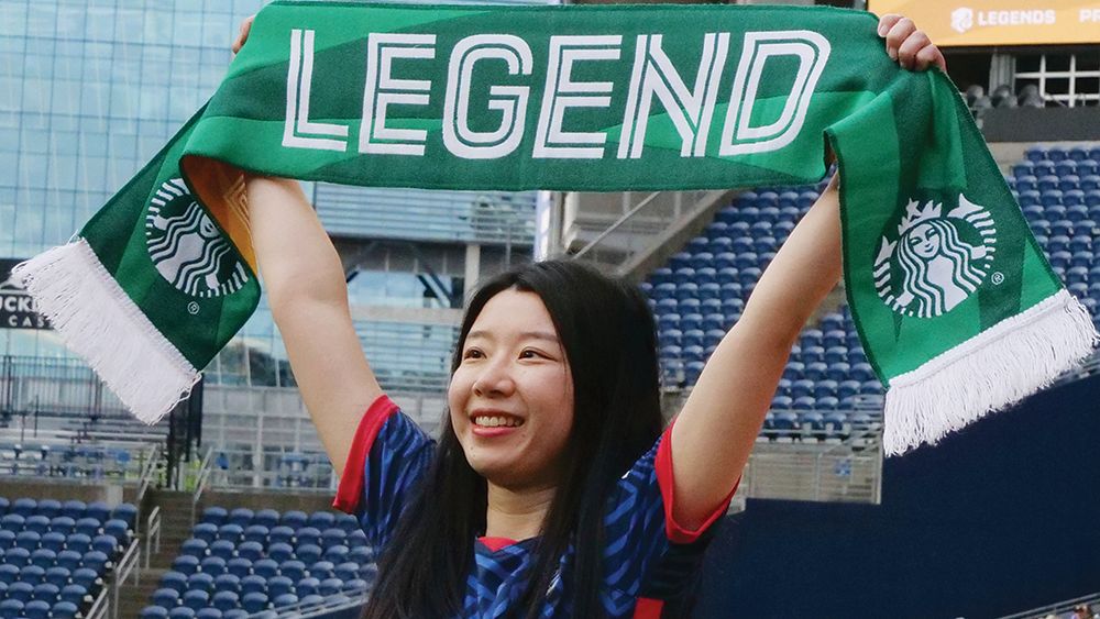 Luna Zhang holds up the Starbucks Legend Scarf Banner