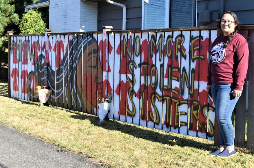 Jennifer Vasilez, '23, Ed.D. Educational Leadership, poses next to a mural raising awareness of missing and murdered Indigenous women on her North Tacoma home's fence.