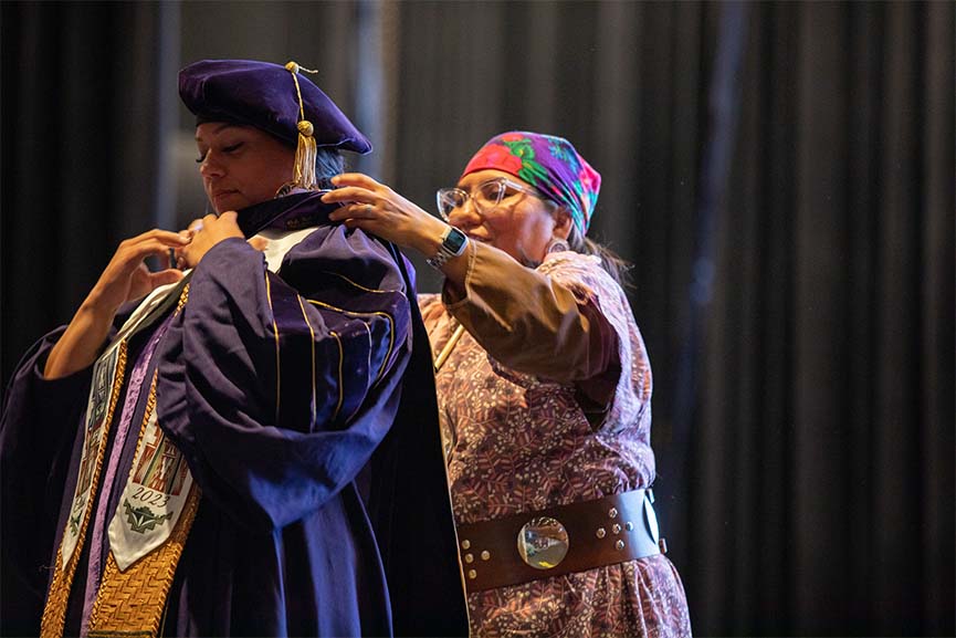Merisa Jones, '23, Ed.D. Educational Leadership (left) receiving doctoral hood from Dr. Robin Minthorn at UW Tacoma School of Education hooding ceremony.