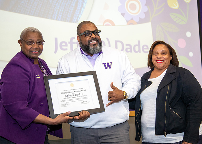 UW Tacoma alumnus Jeff Dade is holding the Distinguished Alumni Award. On his left is Chancellor Sheila Edwards Lange and on his right is Chana Lawson, UW Tacoma's Assistant Director of Alumni Relations & Annual Giving.