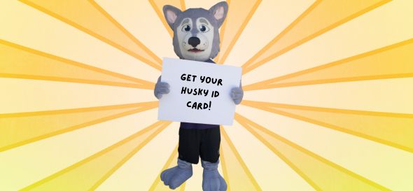 Hendrix holding a signs saying, "Get your Husky ID Card!"
