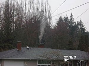 Image showing smoke emerging from a house chimney.