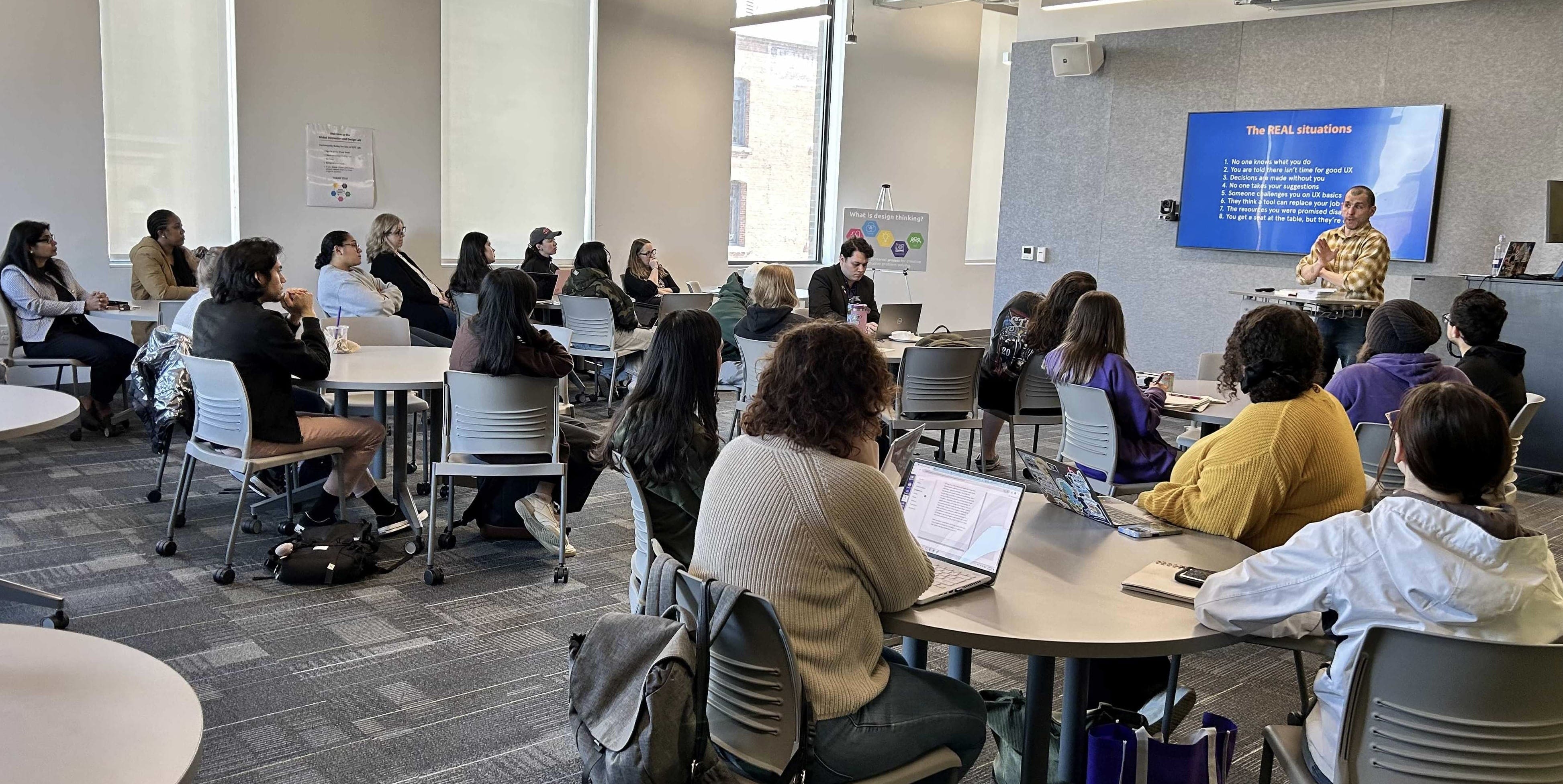 A full house of students listen intently as Berkun shares real-life situations that designers face.