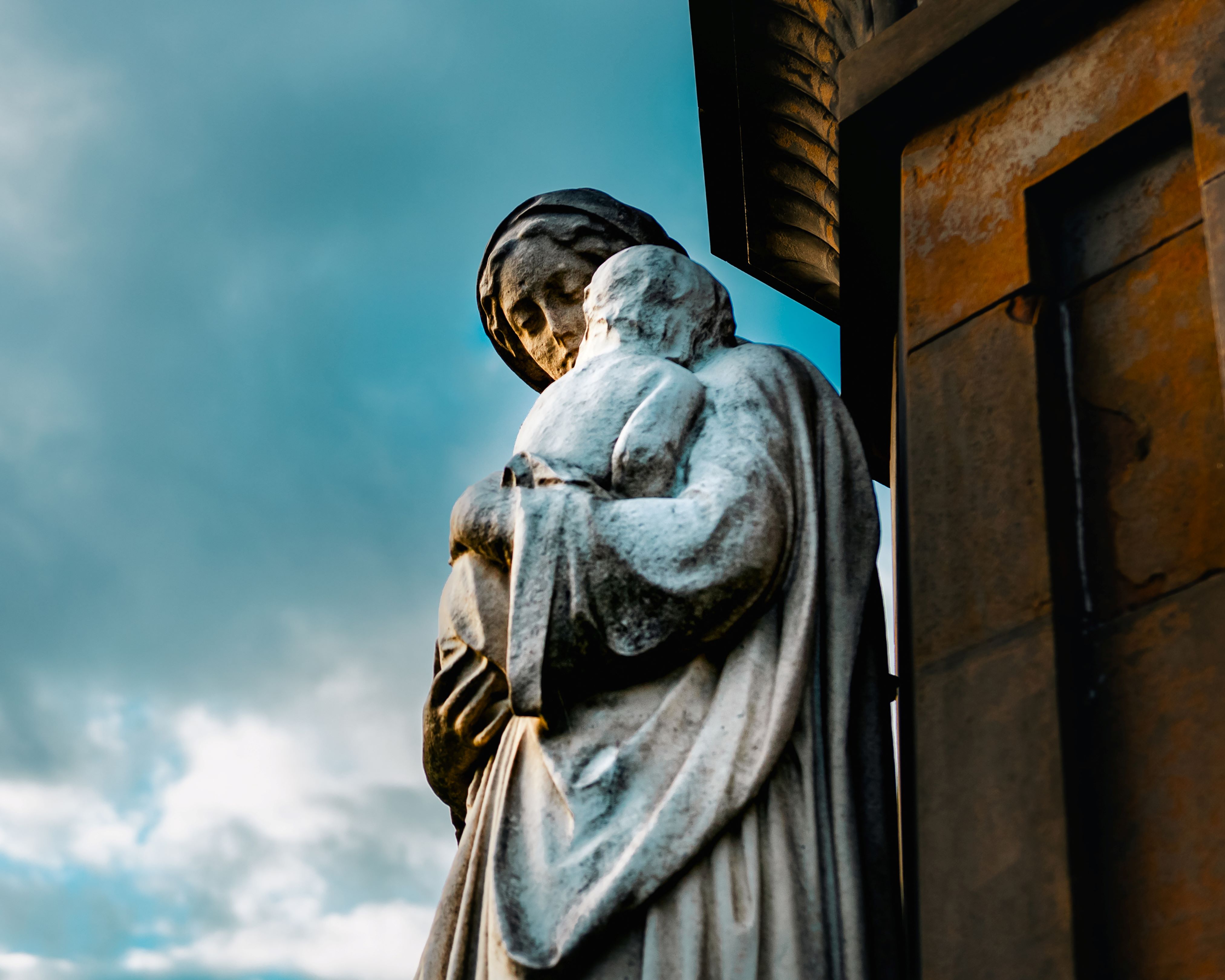 Image of a stone statue of a robed figure holding a baby