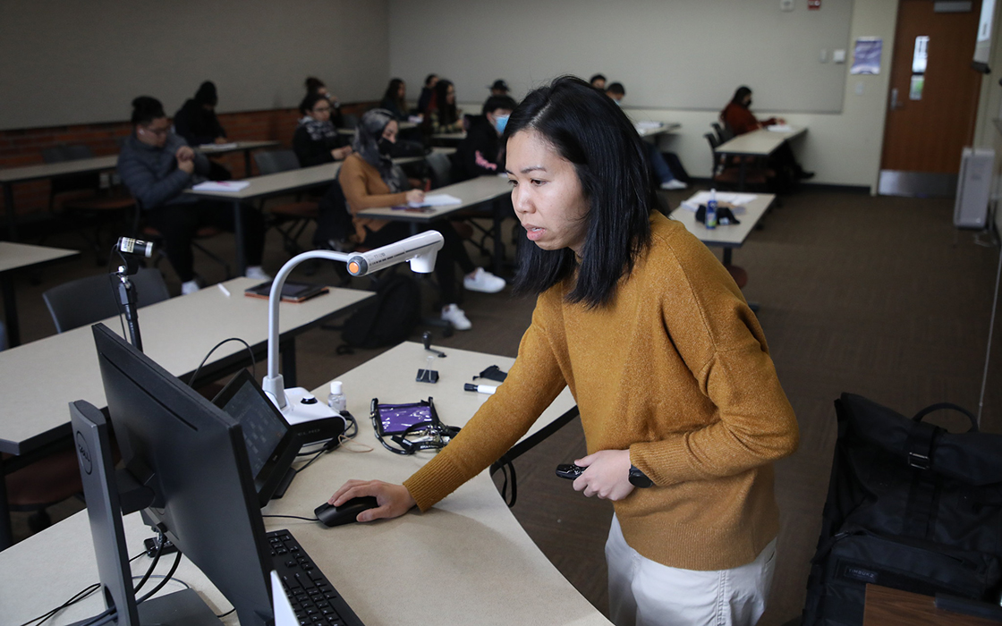 Associate Teaching Professor Rita Than uses a desktop computer in a classroom on UW Tacoma's campus.