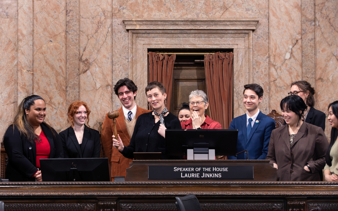 Brooklyn Darling Jay ('23) poses with a gavel on the House floor alongside Speaker Laurie Jinkins (center).