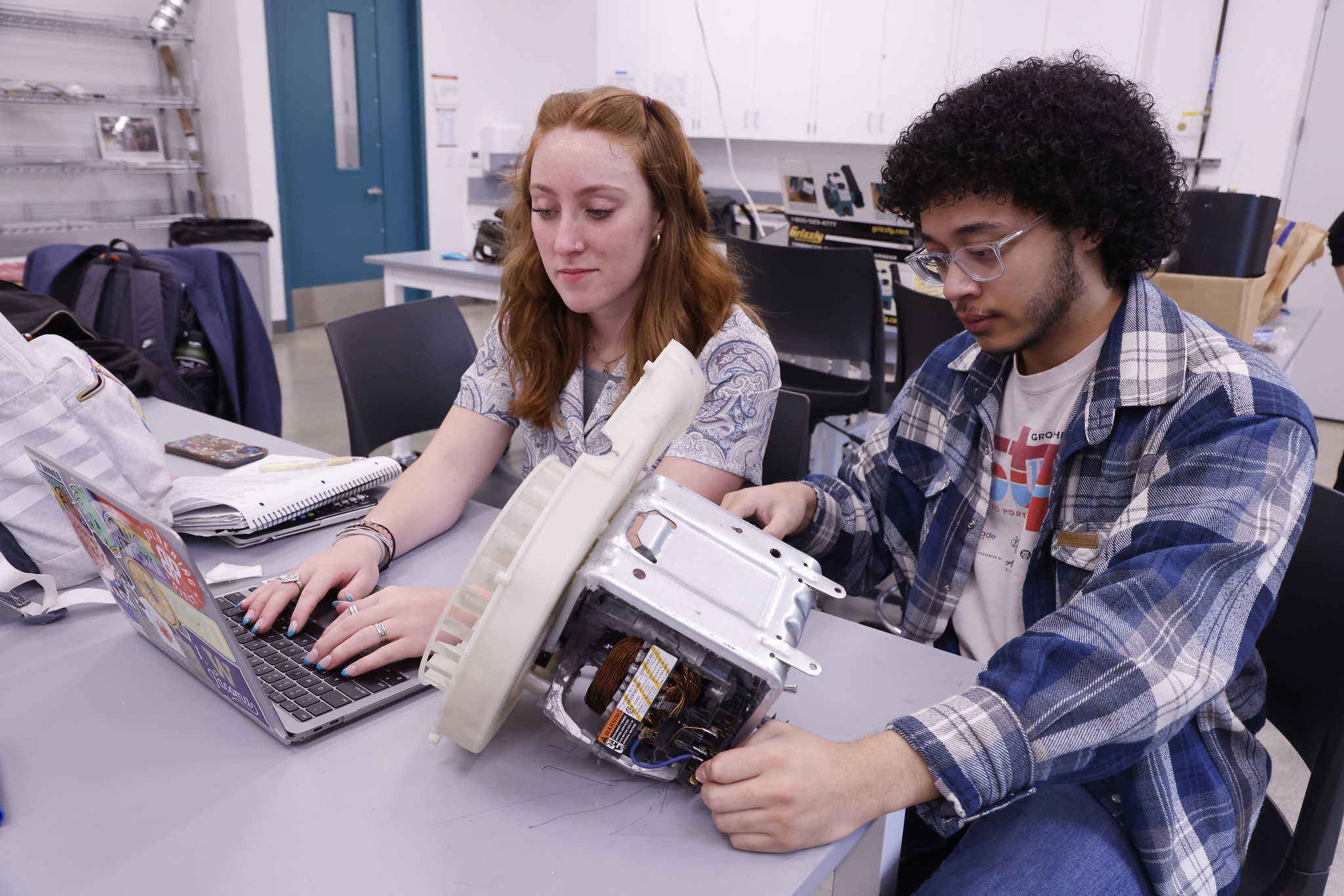 Two students examine a device in a mechanical engineering lab at UW Tacoma
