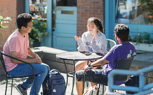 photo of students sitting outside at table