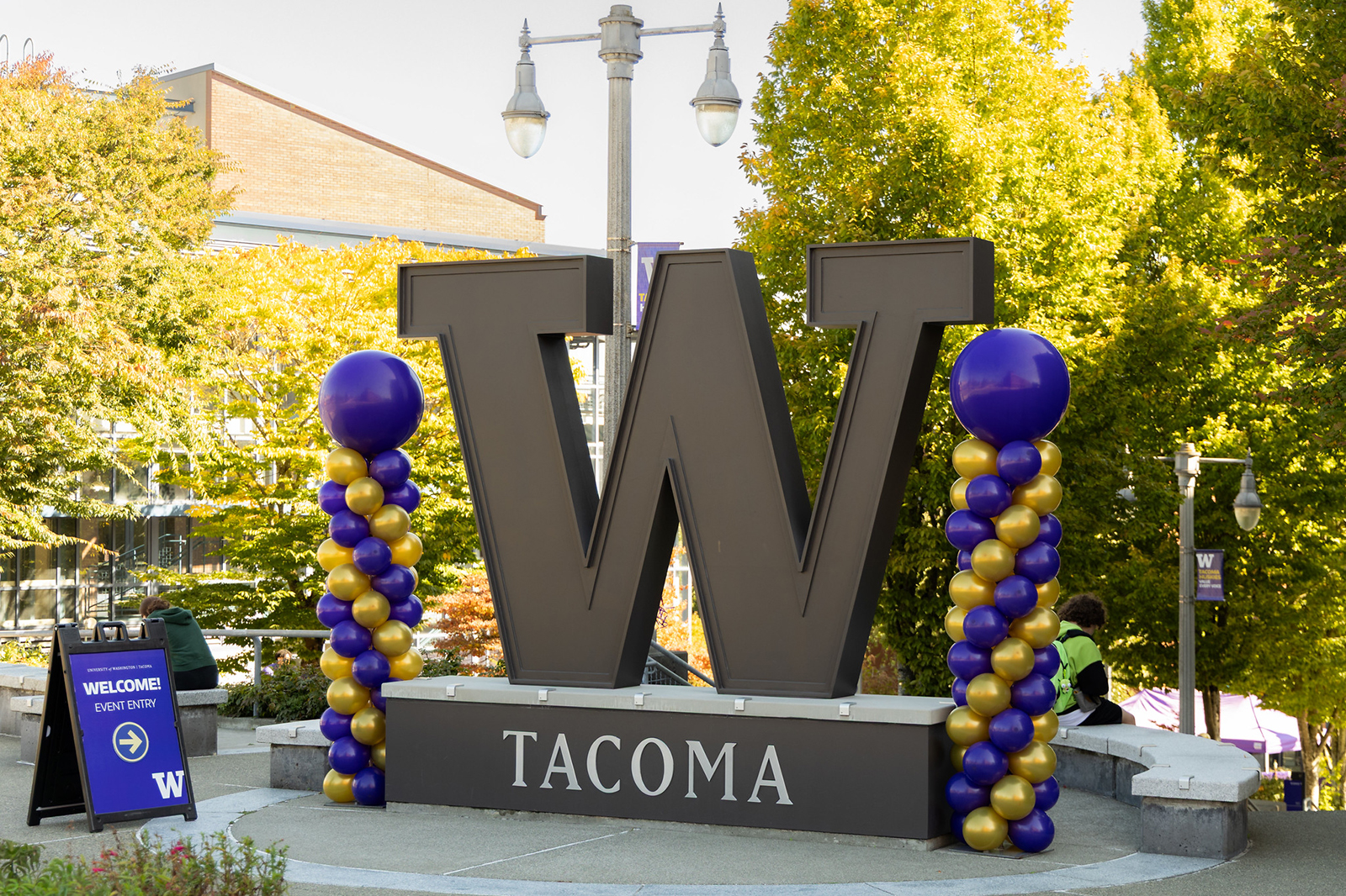 The W statue at UW Tacoma with purple and gold balloons on each side.