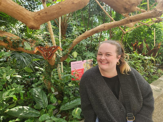 Photo of Rachel Crook posing next to a moth at the zoo