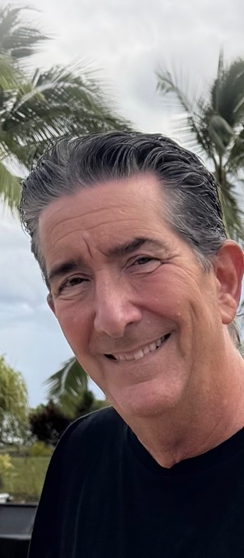 Headshot of Chuck Costarella in front of palm trees