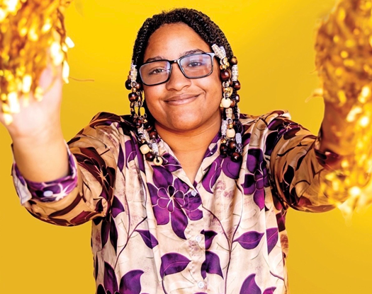 Photo of Qaturi Vaughn holding gold pompoms