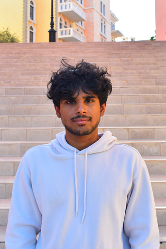 Photo of Chris Biju in front of an outdoor staircase