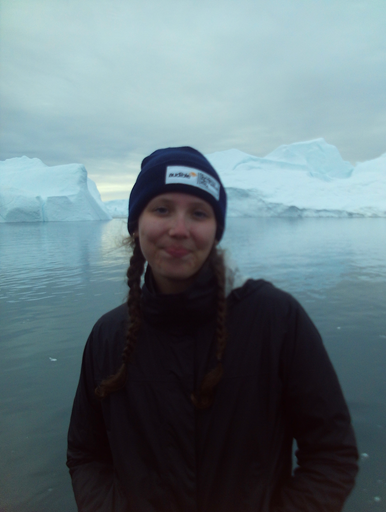 Photo of Isabella Claeson in front of glaciers floating on the water