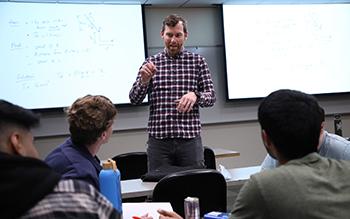 A UW Tacoma faculty member teaches a course to students in a classroom.