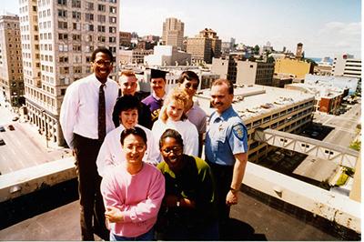 UW Tacoma founding staff with one of the first graduates on the roof of Perkins Building, 1991.