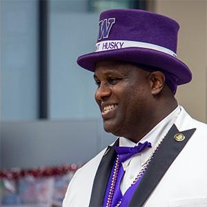 UW Tacoma alumnus Mark Glenn, aka "Sergeant Husky," in purple top hat, purple tie, white jacket, purple vest.