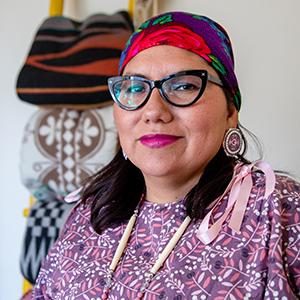 Headshot of UW Tacoma Ed.D. Director Robin Minthorn. Minthorn is wearing glasses, a multicolored headwrap and a floral print dress.