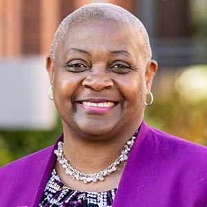 Headshot of UW Tacoma Chancellor Sheila Edwards Lange. She is wearing a purple jacket, necklace and patterned under shirt.