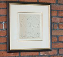 "La Visage de la Paix," by Pablo Picasso, framed art work on brick wall in UW Tacoma Library
