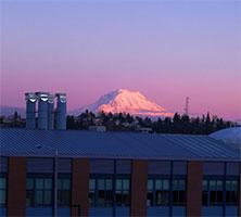 Landscape view of Mount Rainier at sunset, with UW Tacoma buildings in foreground.