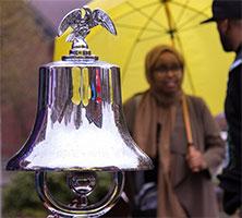 Ceremonial bell with ASUWT President Arwa Dubad in background.