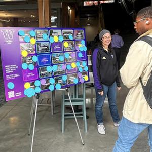 An interactive engagement board on an easel, covered with colorful sticky notes and speech-bubble graphics, displayed in an indoor public space.