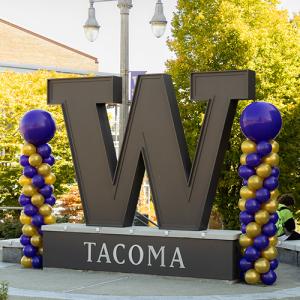 The W statue at UW Tacoma with purple and gold balloons on each side.