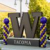The W statue at UW Tacoma with purple and gold balloons on each side.
