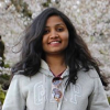 ShrustiShree (Shru) Sumanth, MSCSS student, with a backdrop of white cherry blossoms